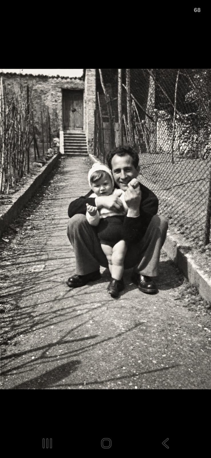 Fotografia de família em preto e branco: um homem com uma criança no colo.